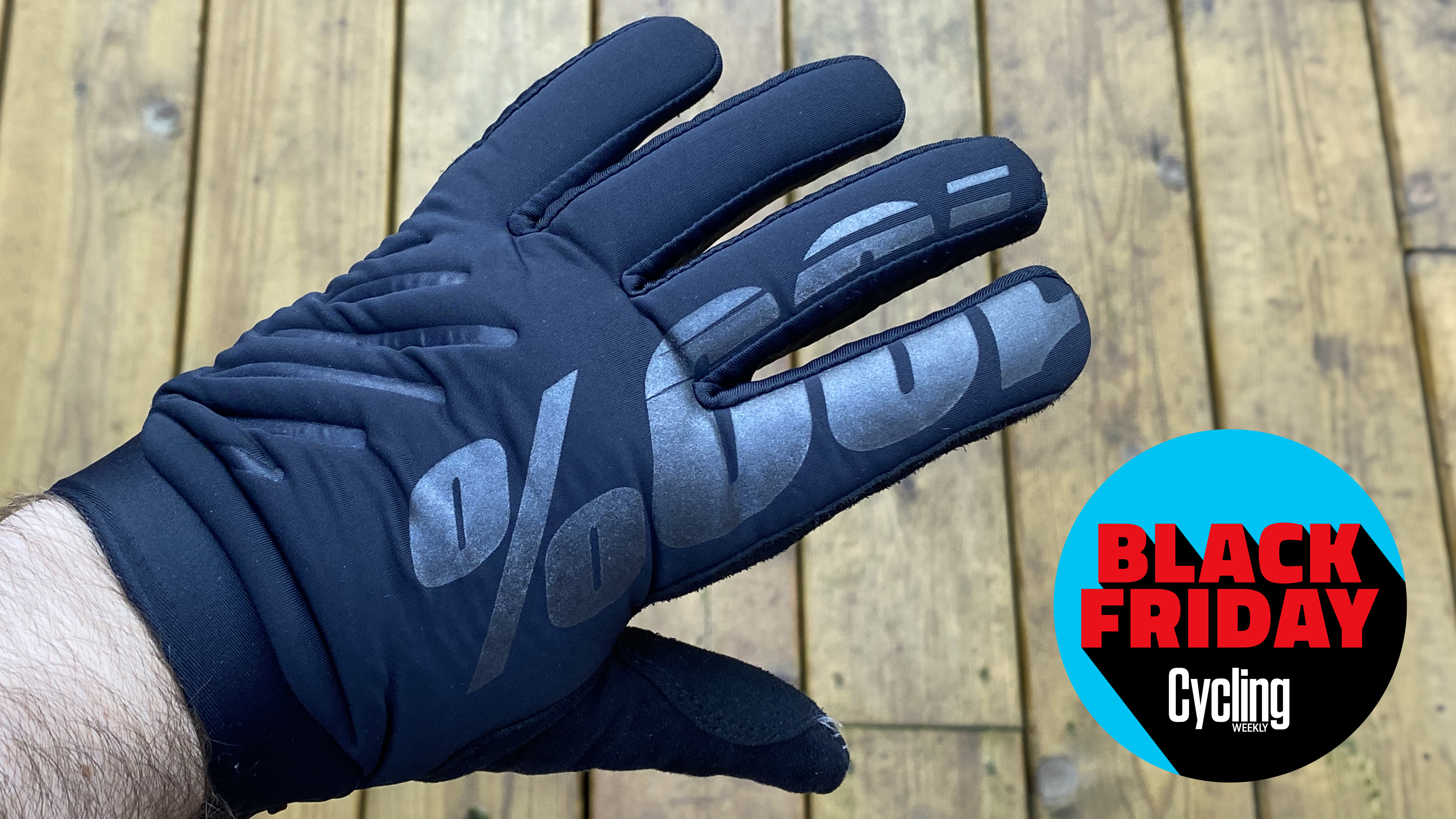 Brisker winter gloves warn showing the 100% logo across two fingers and the hand, alongside the Cycling Weekly Black Friday Bike deals roundel.